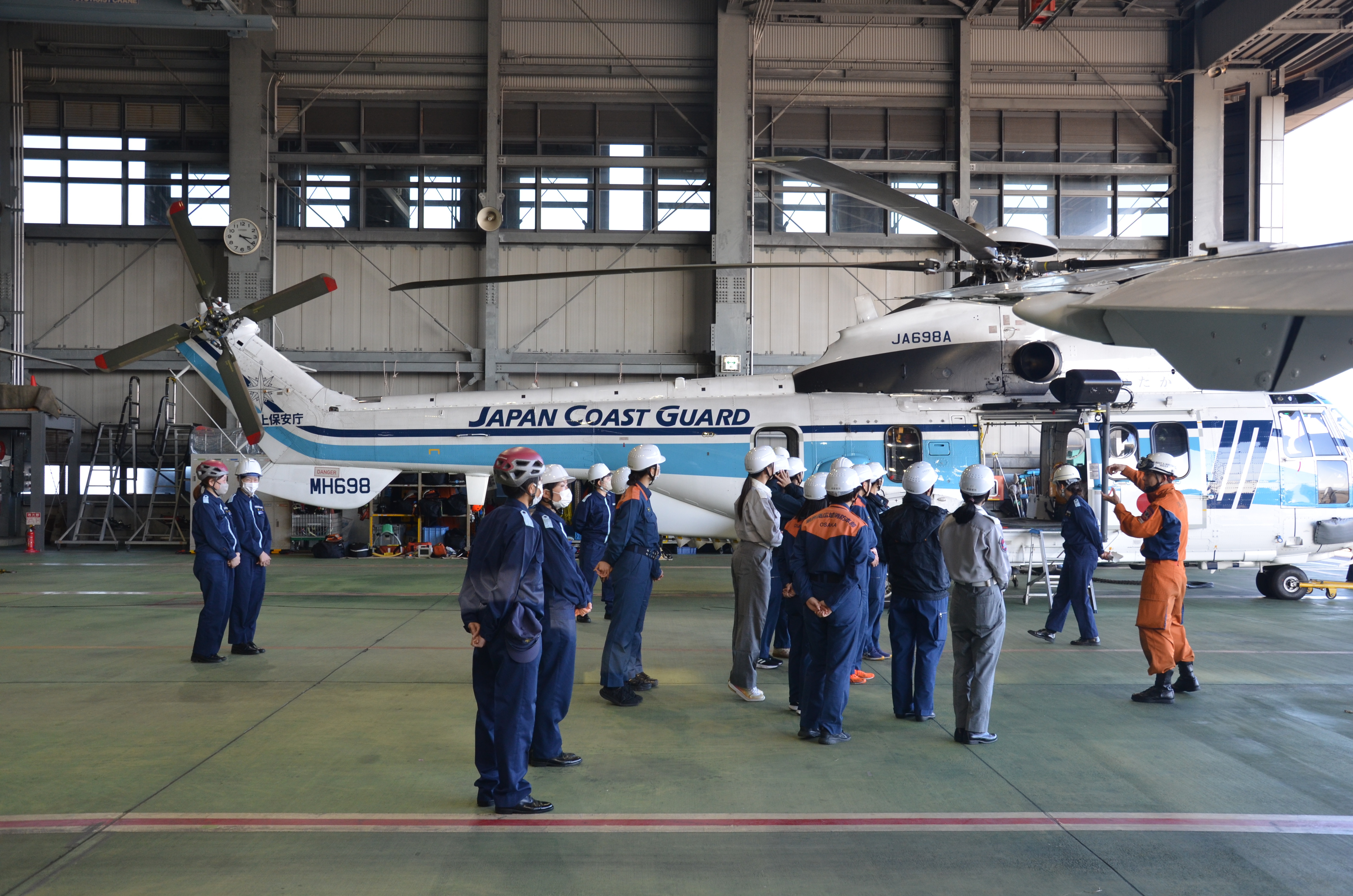 格納庫で航空機の説明を受けている写真.JPG